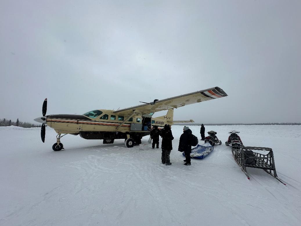 A plane parked on the snow
Description automatically generated